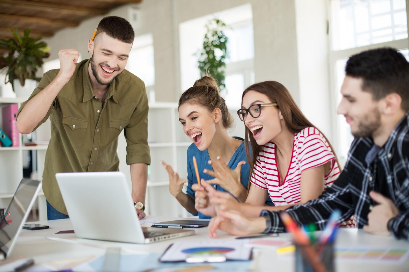 Affiliate marketing team celebrating success working on partnership program in modern office
