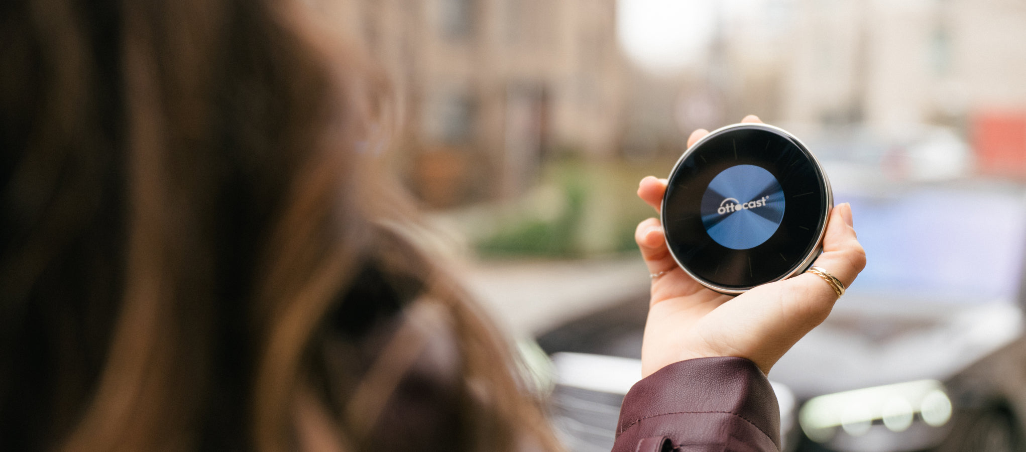 Person holding Ottocast wireless CarPlay AI Box portable device for in-car smart connectivity and multimedia streaming
