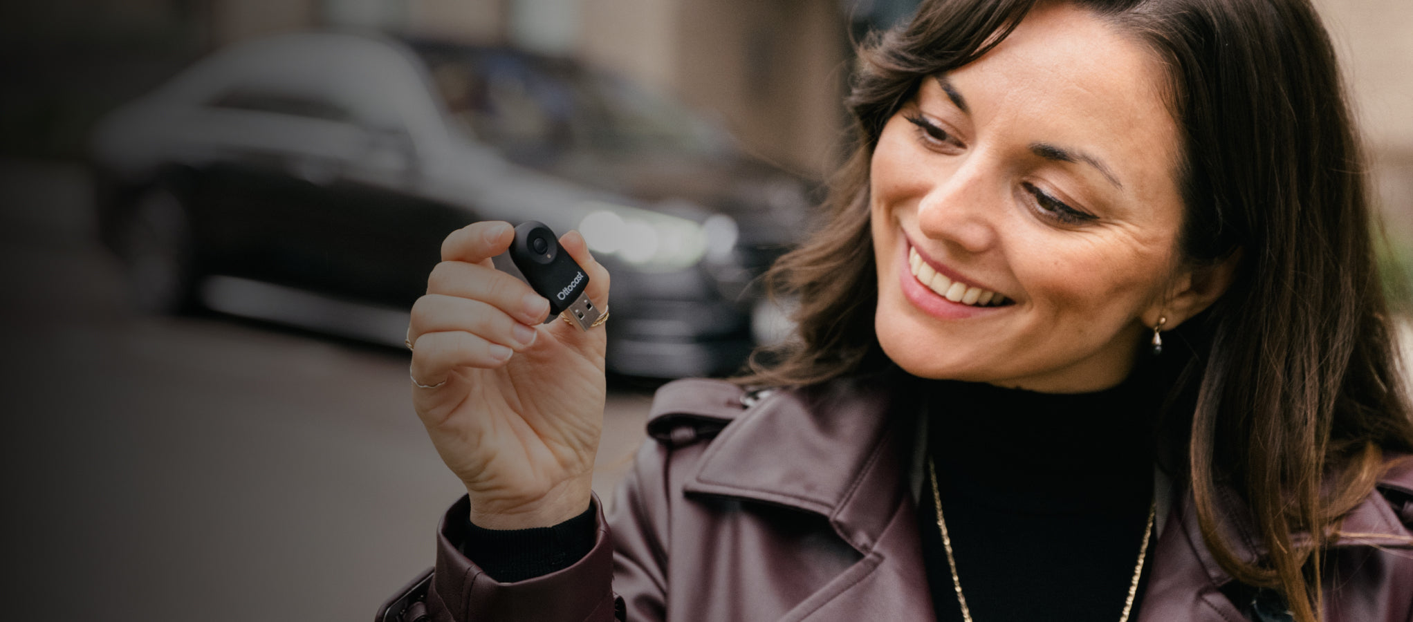 Smiling woman holding Ottocast wireless CarPlay adapter for smart in-car connectivity and media streaming （有重复图片序列号为13）