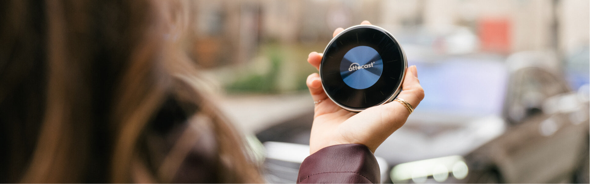 Person holding Ottocast AI Box device for wireless CarPlay and Android Auto in-car smart connectivity